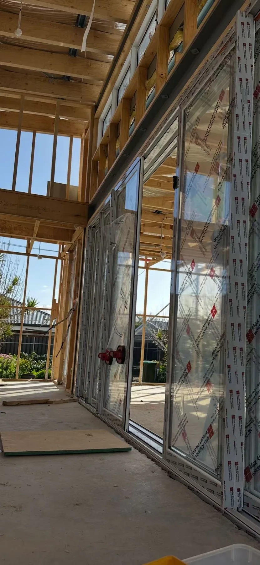 Aluminium sliding door installation within a timber-framed residential construction site